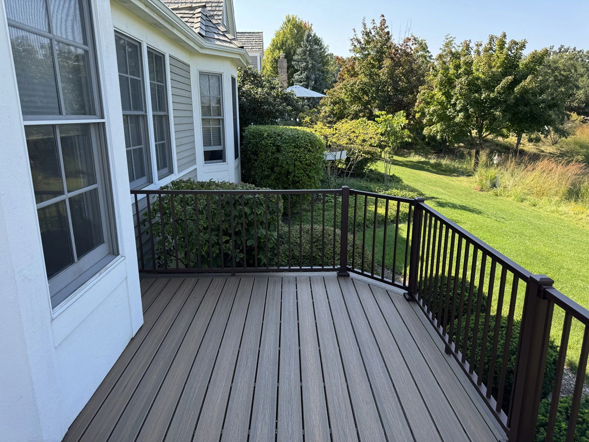 New Composite Deck With Dark Aluminum Railings Overlooking A Green Backyard