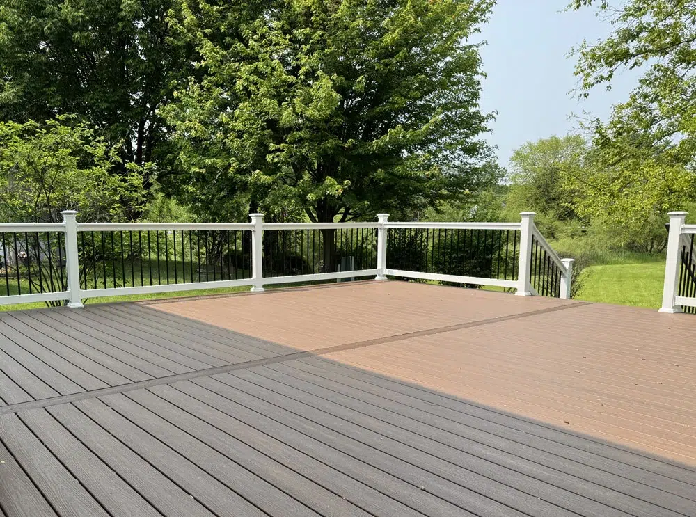 Close-Up Of Composite Deck Boards And White Pvc Railing With Black Aluminum Balusters Showing Professional Deck Installation Quality