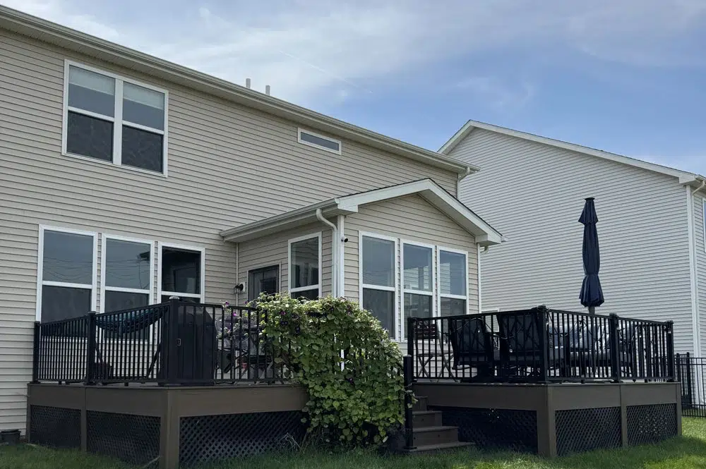 Well-Maintained Composite Deck With White Railings And Patio Furniture